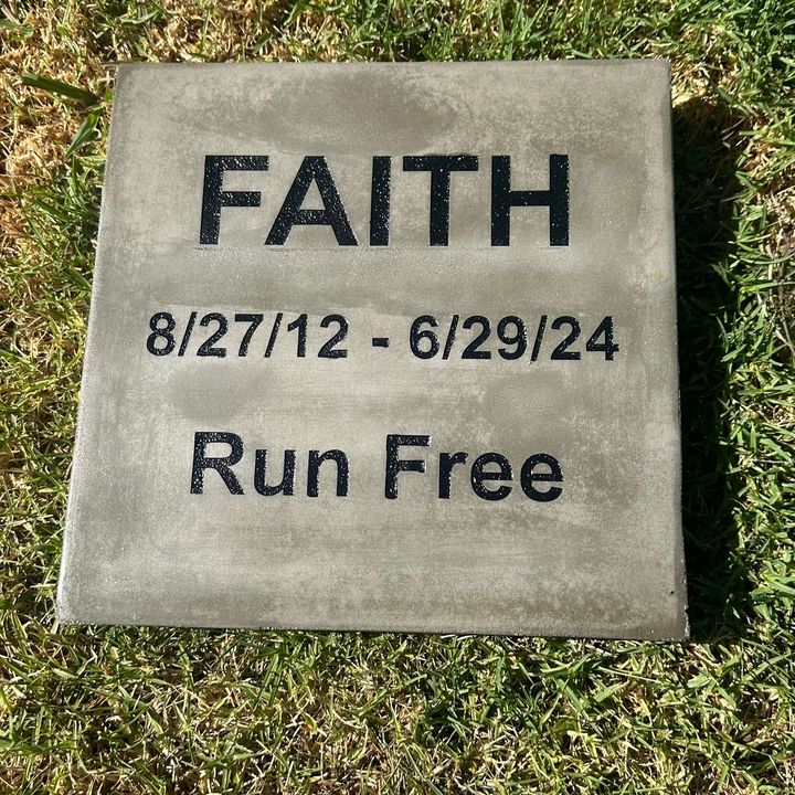 Grave marker with 'FAITH' and dates on a grassy background