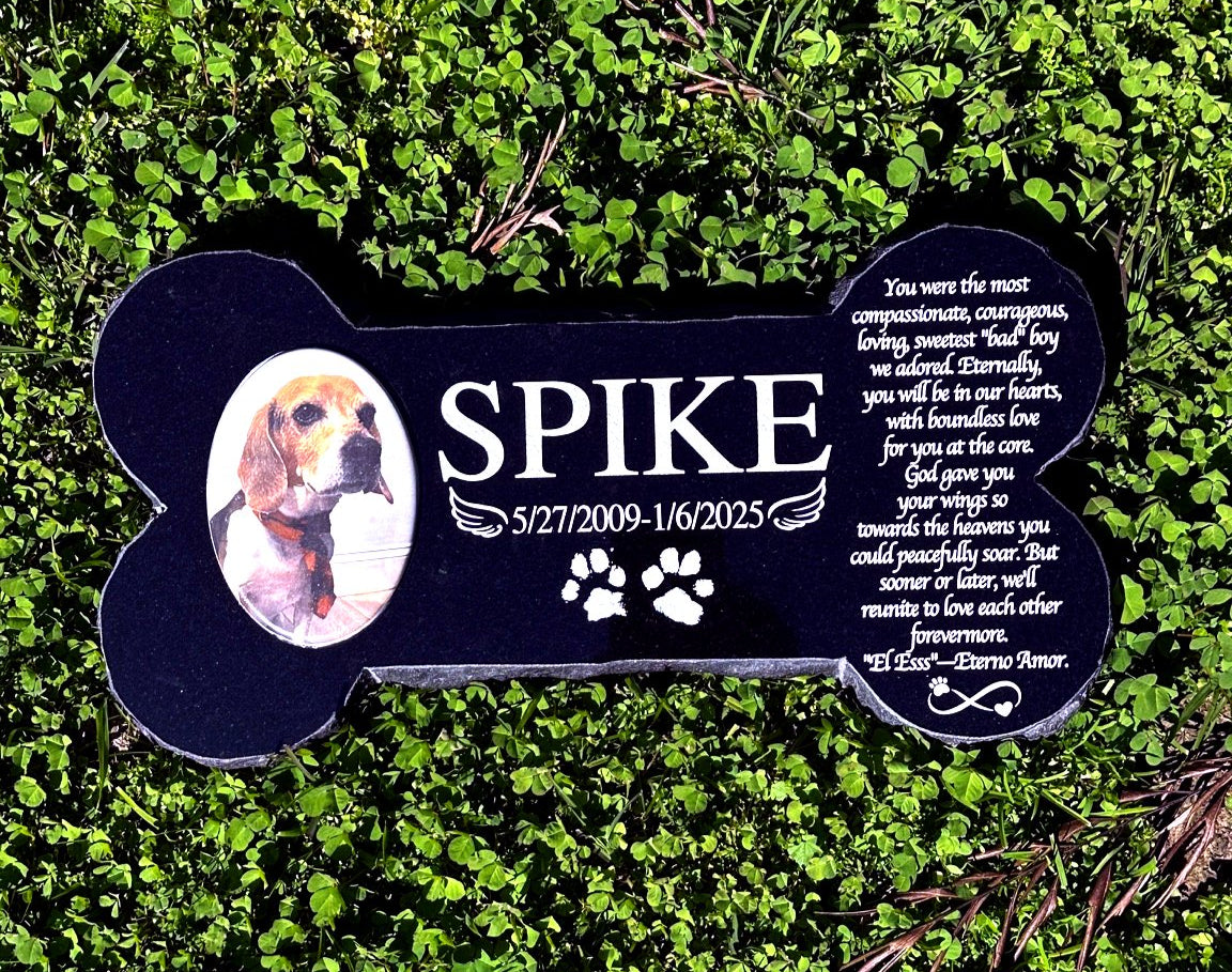 Bone-shaped black granite dog memorial displayed outdoors