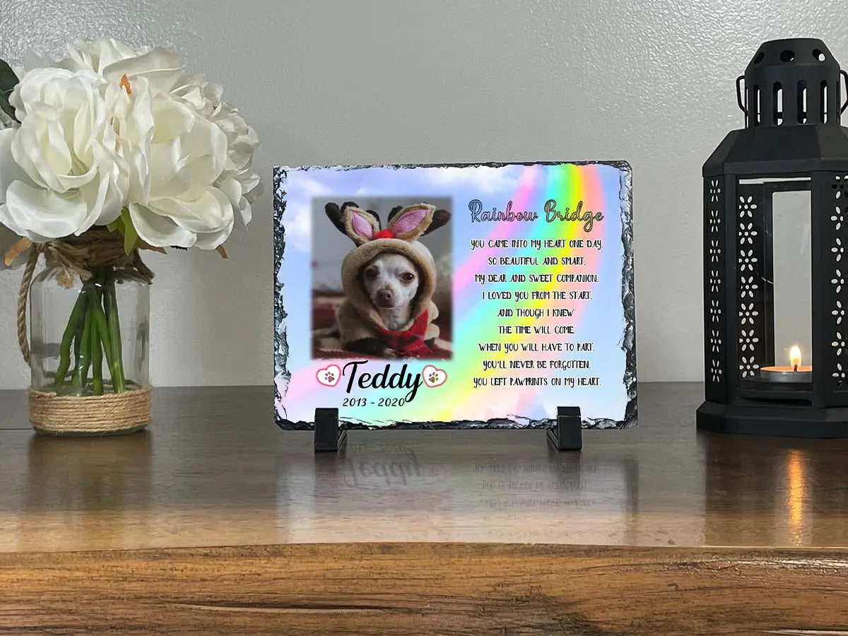 Personalized dog memorial slate for Teddy displayed between white flowers and a candle lantern